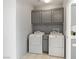 Practical laundry room with washer, dryer, and overhead cabinets at 6635 Caporetto Ln # 204, North Las Vegas, NV 89084