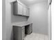 Functional laundry room with gray cabinets and a built-in desk area at 6635 Caporetto Ln # 204, North Las Vegas, NV 89084