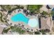 Aerial view of a freeform pool surrounded by lounge chairs, umbrellas, and palm trees offering a relaxing outdoor oasis at 6635 Caporetto Ln # 204, North Las Vegas, NV 89084