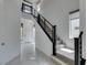 Bright entryway showcasing a staircase with modern railings, tiled floors, and a view of the front door at 681 Stone Hammer Ave, Las Vegas, NV 89183