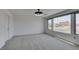 Large living room with plush carpeting and ample natural light from a bank of windows at 681 Stone Hammer Ave, Las Vegas, NV 89183