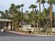 View of a community sign at the entrance surrounded by lush landscaping and mature palm trees at 7135 S Durango Dr # 106, Las Vegas, NV 89113