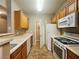 Functional kitchen is equipped with a white appliances, tile floors, and wood cabinets at 7135 S Durango Dr # 106, Las Vegas, NV 89113