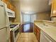Open-concept kitchen with white appliances offering a view into a brightly lit living room at 7135 S Durango Dr # 106, Las Vegas, NV 89113