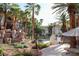 The pool area features a waterfall rock feature, palm trees, and comfortable seating at 7135 S Durango Dr # 106, Las Vegas, NV 89113