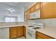 Kitchen featuring wooden cabinets, white appliances and a breakfast bar at 7163 S Durango Dr # 302, Las Vegas, NV 89113