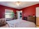 Bright bedroom with a red accent wall, ceiling fan and access to an ensuite bathroom at 7255 W Sunset Rd # 2030, Las Vegas, NV 89113