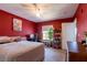 Comfortable bedroom with red walls, neutral carpet, a window, and a work station at 7255 W Sunset Rd # 2030, Las Vegas, NV 89113