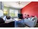 Bright living room with lots of natural light, a red accent wall, and comfortable seating arrangements at 7255 W Sunset Rd # 2030, Las Vegas, NV 89113