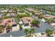 Aerial view of tile roof homes in a desert community, featuring lush landscaping and solar panels at 7286 Mount Kearsarge St, Las Vegas, NV 89131