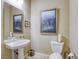 Powder room with pedestal sink, toilet and decorative artwork at 7286 Mount Kearsarge St, Las Vegas, NV 89131