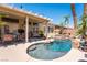 Beautiful backyard pool featuring a spa, rock waterfall, and comfortable outdoor seating under a covered patio at 7540 Flowing Stream Dr, Las Vegas, NV 89131