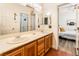 Bathroom with double sinks and tile floor, with views of a bedroom through the door at 7540 Flowing Stream Dr, Las Vegas, NV 89131