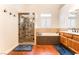 Bathroom featuring a walk-in shower and a soaking tub with tile surround and wood vanity at 7540 Flowing Stream Dr, Las Vegas, NV 89131