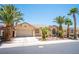 Charming single-story home with a two-car garage, desert landscaping, and mature palm trees at 7540 Flowing Stream Dr, Las Vegas, NV 89131