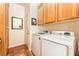 Practical laundry room equipped with modern washer and dryer, cabinets, and convenient mirror at 7540 Flowing Stream Dr, Las Vegas, NV 89131