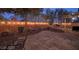 Spacious backyard with flagstone patio, landscape lighting and lush greenery creating a serene and inviting atmosphere at 7728 Whispering River St, Las Vegas, NV 89131