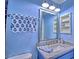 Fresh bathroom features stylish blue paint, updated lighting and modern hardware at 7728 Whispering River St, Las Vegas, NV 89131