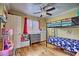 Bright bedroom with ceiling fan features a bunk bed, gray dresser, and window with shutters at 7728 Whispering River St, Las Vegas, NV 89131