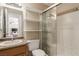 Cozy bathroom featuring a neutral vanity, tiled shower with glass doors, and white shelving at 8041 Astrology Ct # 201, Las Vegas, NV 89128