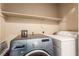 Laundry room featuring a modern washer and dryer with upper storage shelves for organization at 8041 Astrology Ct # 201, Las Vegas, NV 89128