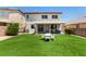 Wide backyard with artificial turf, covered patio, and privacy fence at 8061 Palace Estate Ave, Las Vegas, NV 89117