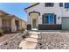 Inviting front entrance with desert landscaping leading to an olive-green front door and two-car garage at 8061 Palace Estate Ave, Las Vegas, NV 89117