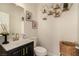 Stylish half bath with black vanity, framed art, honeycomb shelves, and elegant fixtures at 8061 Palace Estate Ave, Las Vegas, NV 89117