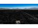 Monochrome aerial of neighborhood with one house in color showing surrounding landscape, nearby road, and open sky at 816 Sandsprings St, Henderson, NV 89011
