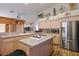 Well-lit kitchen with stainless steel refrigerator, tile countertops, and a central island cooktop at 816 Sandsprings St, Henderson, NV 89011