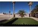 Lush backyard showcasing palm trees, artificial turf, and desert landscaping, perfect for outdoor enjoyment and relaxation at 851 Brahma Ln, Henderson, NV 89002