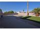 Spacious backyard with concrete patio, desert landscaping, palm trees, and artificial turf, ideal for entertaining and relaxation at 851 Brahma Ln, Henderson, NV 89002