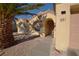 Close-up view of entrance featuring well maintained stucco exterior and mature palm trees at 851 Brahma Ln, Henderson, NV 89002