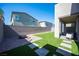 Cozy backyard with artificial grass, a fire pit, and stepping stones for relaxed outdoor living at 9256 Alden Pointe Ct, Las Vegas, NV 89143
