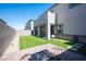 Well-kept backyard with artificial turf, a fire pit, and a covered patio area for entertaining at 9256 Alden Pointe Ct, Las Vegas, NV 89143