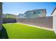 Fenced backyard featuring artificial grass and a compact firepit area for outdoor enjoyment at 9256 Alden Pointe Ct, Las Vegas, NV 89143
