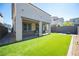 A well-maintained backyard features artificial grass, a patio, and desert landscaping at 9256 Alden Pointe Ct, Las Vegas, NV 89143