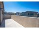 Spacious outdoor balcony with textured wall and neighborhood views under a clear blue sky at 9256 Alden Pointe Ct, Las Vegas, NV 89143