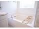 Clean, bright bathroom featuring a modern tub with a wooden bath caddy and white subway tile surround at 9256 Alden Pointe Ct, Las Vegas, NV 89143