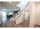 Spacious entry featuring wood-look floors, white staircase, and view of living area at 9256 Alden Pointe Ct, Las Vegas, NV 89143