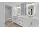 Bright bathroom featuring double sinks, white cabinets, gold fixtures, and a marble-tiled shower at 9412 Mount Cherie Ave # 102, Las Vegas, NV 89129