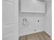 White laundry room features overhead cabinets, washer hookups, and a white door at 9412 Mount Cherie Ave # 102, Las Vegas, NV 89129
