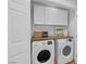 Bright laundry room with a washer and dryer, storage cabinets, and decorative elements at 9412 Mount Cherie Ave # 102, Las Vegas, NV 89129