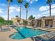 Beautiful community pool area with clear blue water and many lounge chairs and seating areas, surrounded by green landscaping at 9412 Mount Cherie Ave # 102, Las Vegas, NV 89129