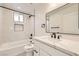 Stylish bathroom featuring modern vanity, tub, shower, and a well-lit mirror at 9712 Rocket Grove Ct, Las Vegas, NV 89178