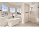 Modern bathroom showcasing a sleek standalone tub, walk-in shower, and scenic window views at 9712 Rocket Grove Ct, Las Vegas, NV 89178
