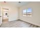 A bedroom featuring modern flooring, light-colored walls, and a view of the neighborhood at 9712 Rocket Grove Ct, Las Vegas, NV 89178