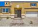 Close up of an inviting yellow home featuring a tile roof and charming brick walkway leading up to the front door at 9712 Rocket Grove Ct, Las Vegas, NV 89178