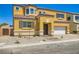 Inviting yellow two-story home featuring a tile roof, charming brick walkway, and attached two-car garage at 9712 Rocket Grove Ct, Las Vegas, NV 89178