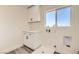 Bright laundry room with a large window, white cabinets, and countertop space at 9712 Rocket Grove Ct, Las Vegas, NV 89178